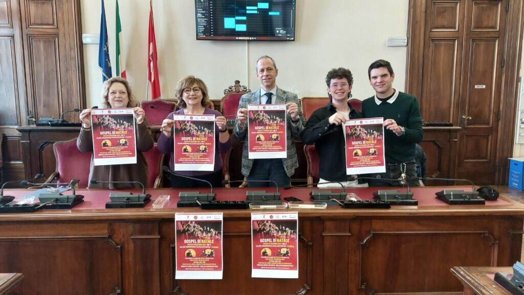 “Gospel di Natale”. Locandina dell’evento e fotografia della conferenza stampa di presentazione svoltasi stamane nella sala del Consiglio comunale in Municipio.