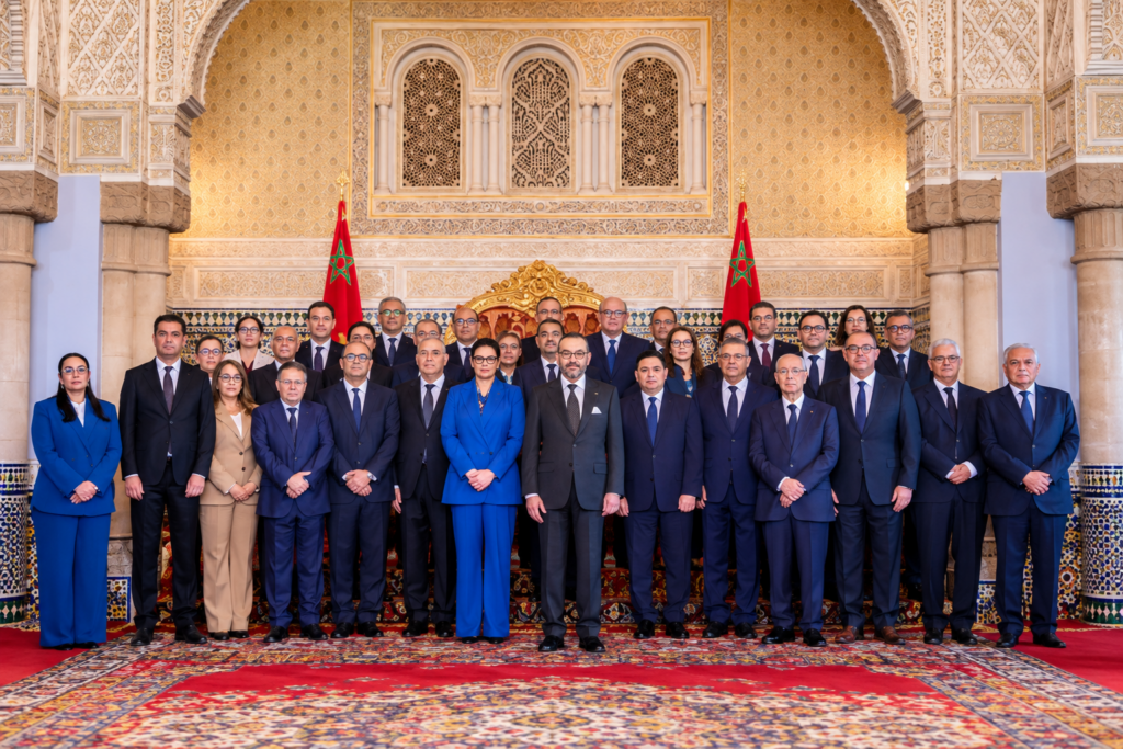 Rappresentazione illustrativa del nuovo governo marocchino in una sala istituzionale, con le bandiere del Marocco.